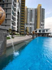 una gran piscina con una fuente frente a los edificios en Family friendly multiple Parking 3bedroom apartment en Seri Kembangan