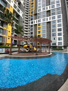 una piscina con parque infantil frente a edificios altos en Family friendly multiple Parking 3bedroom apartment en Seri Kembangan