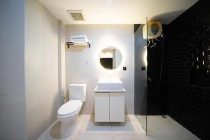 y baño con aseo, lavabo y espejo. en DS Colive Sinabung en Candi