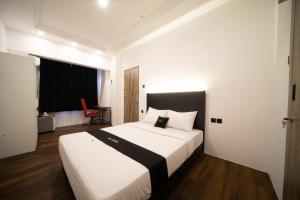 a bedroom with a large white bed with a black headboard at DS Colive Sinabung in Candi