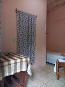 a room with a table and a bed and a window at Hostal Delmy in Suchitoto