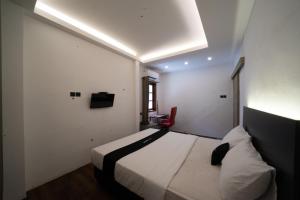 Habitación de hotel con cama y silla roja en DS Colive Sinabung en Candi