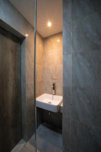 y baño con lavabo y ducha acristalada. en DS Colive Sinabung en Candi