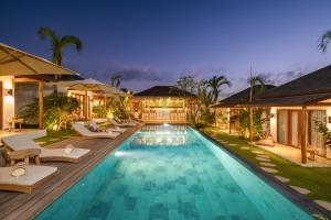 a villa with a swimming pool at night at EHOA BALI Nyanyi Boutique Hotel - In front of entrance to NUANU in Tanah Lot
