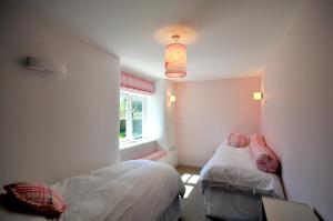 a small bedroom with two beds and a window at Culverwells in Axminster