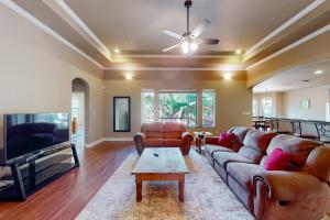 a living room with couches and a flat screen tv at Captivating Cottage in New Braunfels