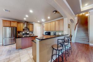 une cuisine avec des placards en bois et des tabourets de bar dans l'établissement Captivating Cottage, à New Braunfels