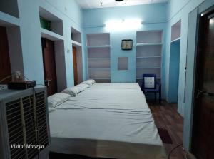 Habitación con 3 camas en una habitación con paredes azules. en Maa Tara AC Home Stay en Varanasi