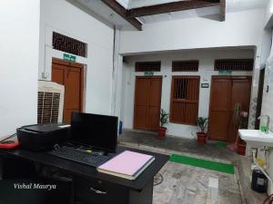 um escritório com uma secretária e um computador portátil em Maa Tara AC Home Stay em Varanasi