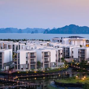 un gran edificio de apartamentos blanco junto al agua en Hạ Long Gem Hotel en Ha Long