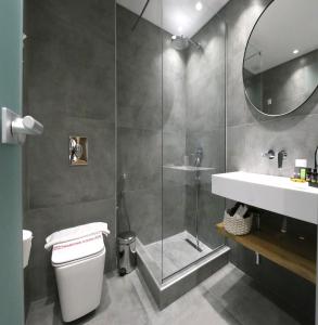 e bagno con doccia, servizi igienici e lavandino. di The Oak Hotel a Keramotí