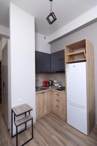 a kitchen with a white refrigerator and a stool at Цахкадзор кечи аус Уютное студио с видом на лес - Cozy studio with stunning forest views in Tsaghkadzor
