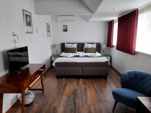 a bedroom with a bed and a desk and a couch at Hotel Bed & Breakfast De Poffert in Borger