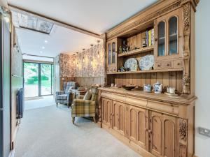 a kitchen with wooden cabinets and a dining room at Eeyores House - Uk43487 in Aldington