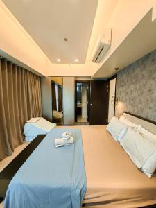 een hotelkamer met een groot bed met een handdoek erop bij Grand Deluxe 3BR with Bathtub in Uptown BGC in Manilla