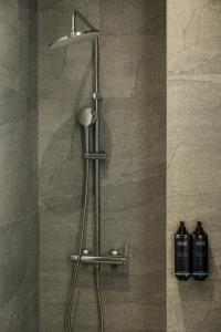 a shower with a shower head in a bathroom at Aristotelous Downtown Suites in Thessaloniki