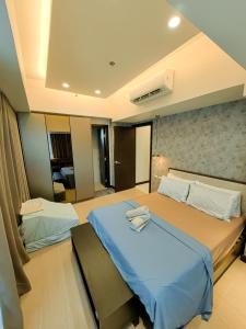 een slaapkamer met 2 bedden en een blauwe deken bij Grand Deluxe 3BR with Bathtub in Uptown BGC in Manilla
