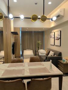 een woonkamer met een tafel en stoelen bij Grand Deluxe 3BR with Bathtub in Uptown BGC in Manilla