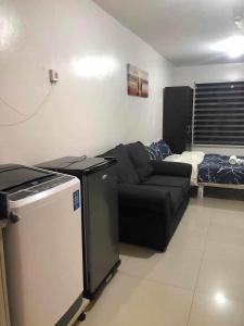 een woonkamer met een bank en een bed bij L & R Staycation in Imus
