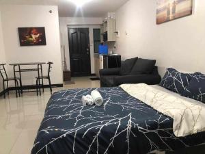 a bedroom with a bed and a living room at L & R Staycation in Imus