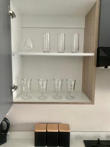 a row of glasses on a shelf in a kitchen at Ladybug unit 3 (2) in Midrand
