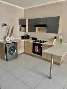 a kitchen with a stove and a washing machine at Ladybug unit 3 (2) in Midrand