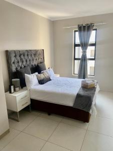a bedroom with a large bed and a window at Ladybug unit 3 (2) in Midrand