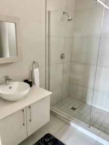 a bathroom with a shower and a sink at Ladybug unit 3 (2) in Midrand