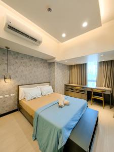 een slaapkamer met een groot bed en een bureau bij Grand Deluxe 3BR with Bathtub in Uptown BGC in Manilla