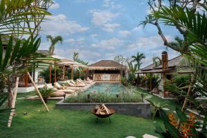 a resort yard with a pool and a house at EHOA BALI Nyanyi Boutique Hotel - In front of entrance to NUANU in Tanah Lot
