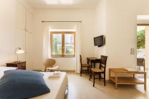 a bedroom with a bed and a desk and a television at Villa Mazzella in Procida