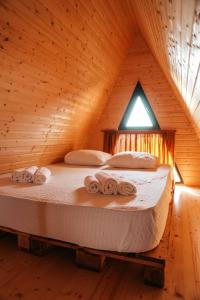 a bed in a wooden room with towels on it at Mandar Inn in Ts'ikhisdziri