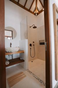 a bathroom with a shower with a glass door at EHOA BALI Nyanyi Boutique Hotel - In front of entrance to NUANU in Tanah Lot