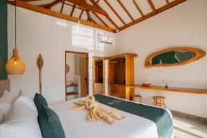 a bedroom with a large white bed in a room at EHOA BALI Nyanyi Boutique Hotel - In front of entrance to NUANU in Tanah Lot