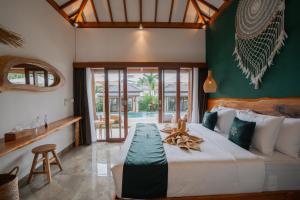 a bedroom with a large bed in a room at EHOA BALI Nyanyi Boutique Hotel - In front of entrance to NUANU in Tanah Lot