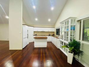 a kitchen with white cabinets and a hard wood floor at Hallorans Hill Holiday Home in Atherton