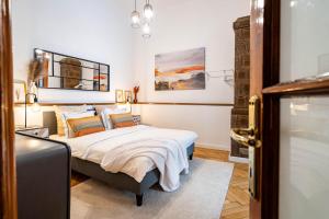 een slaapkamer met een bed en schilderijen aan de muur bij The- POINT- 3BR Bright Cloud in Boekarest