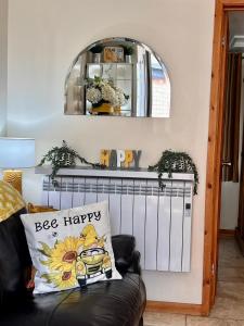 a living room with a black couch and a mirror at Beautiful Bijou Bungalow in Gloucester