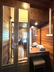 een houten kamer met een bureau en een slaapkamer bij Sirilagoona Home Resort in Nong Prue