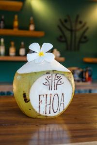 a vase with a flower on it sitting on a table at EHOA BALI Nyanyi Boutique Hotel - In front of entrance to NUANU in Tanah Lot