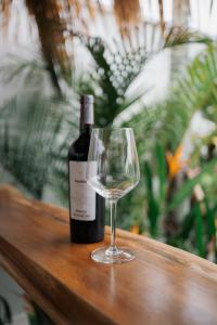 a bottle of wine and a wine glass on a table at EHOA BALI Nyanyi Boutique Hotel - In front of entrance to NUANU in Tanah Lot