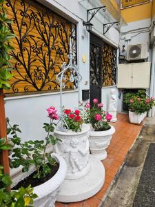 a row of white pots filled with flowers on a sidewalk at A casa di Rita bilocale in Sanremo in Sanremo