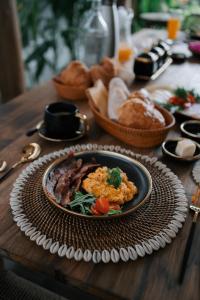 a plate of food on a wooden table with bread at EHOA BALI Nyanyi Boutique Hotel - In front of entrance to NUANU in Tanah Lot