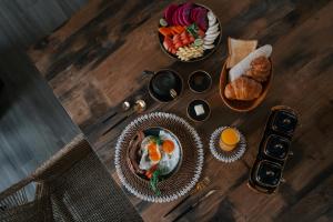 a table topped with plates of food and bowls of fruit at EHOA BALI Nyanyi Boutique Hotel - In front of entrance to NUANU in Tanah Lot