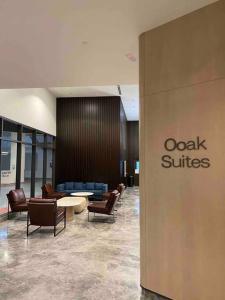 a lobby with a waiting area with chairs and tables at OOAK SUITES AT MONT KIARA KUALA LUMPUR in Kuala Lumpur