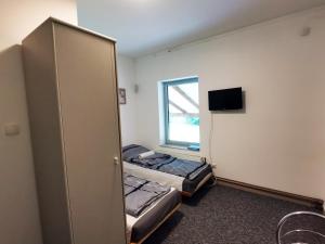 Cette petite chambre comprend 2 lits et une fenêtre. dans l'établissement Opaa Motel, à Poniatowa