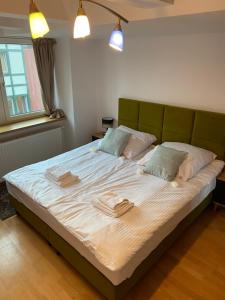 a bedroom with a large bed with two towels on it at Kauris Apartament in Gdańsk
