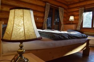 a bedroom with a bed with a lamp on a table at Lodge Tatras in Veľká Lomnica