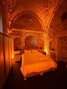 ein Schlafzimmer mit einem großen Bett in einer Steinmauer in der Unterkunft Paşaoğlu Konağı & Boutique hotel in Mardin