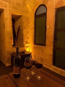 a bottle of wine sitting on a table with two glasses at Paşaoğlu Konağı & Boutique hotel in Mardin